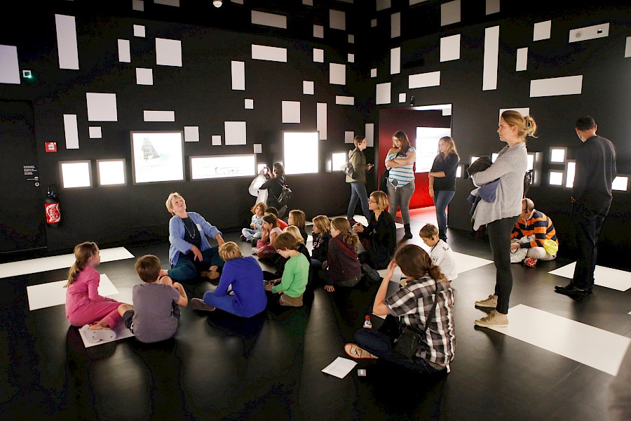 Children sitting around a tour guide